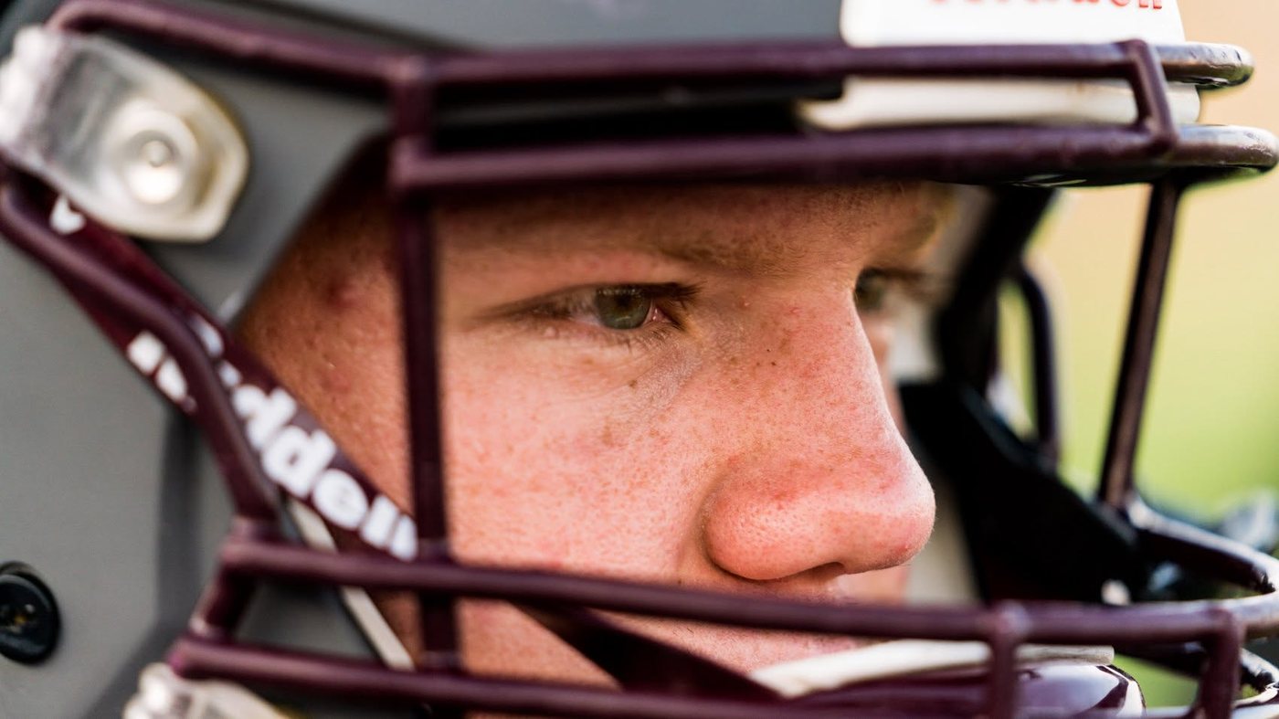 Close-up sports portrait through a football helmet